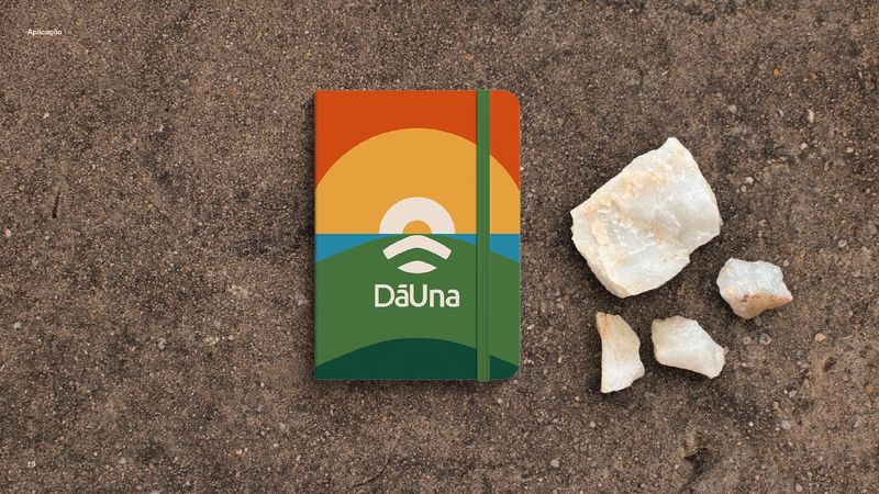 Notebook with the DāUna cover, on sandy soil next to quartz stones